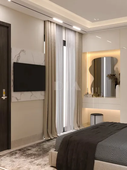 Functionality meets elegance in this bedroom corner, featuring a built-in vanity table with an organically shaped mirror and integrated lighting. A marble panel behind the TV adds a touch of luxury to the minimalist design.