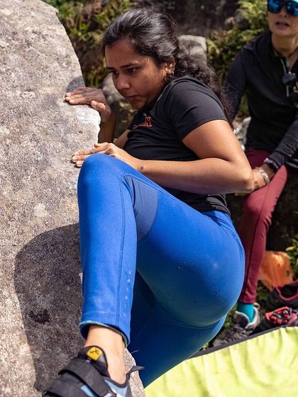 A climber carefully places her foot, demonstrating the precision and balance required in climbing.
