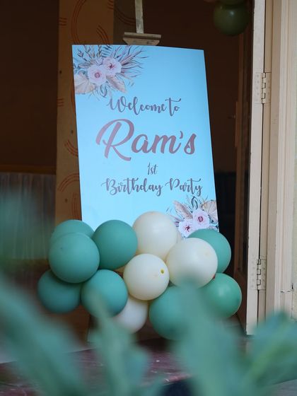 The welcome sign for Ram's first birthday, matching the pastel blue and green color scheme of the main decoration.