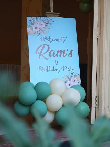 A simple and sweet welcome sign for a first birthday party, with a gentle color scheme and floral accents.