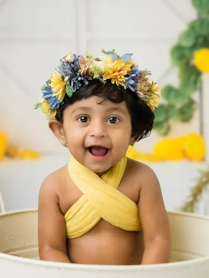 A close-up of this beautiful one-year-old, complete with a flower crown and a huge smile.