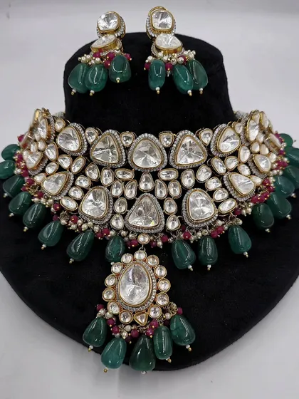 A close-up of the Polki necklace set with triangular stones, showing the intricate details and ruby accents.