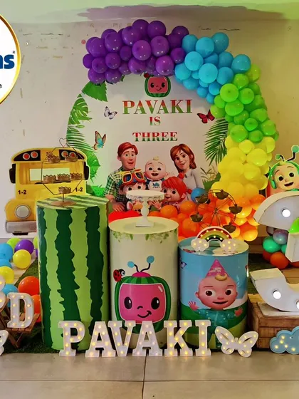 A vibrant and playful Cocomelon theme for a third birthday party. This colorful setup features a rainbow balloon arch, character cutouts, themed plinths, and large light-up numbers, making it a dream come true for any little Cocomelon fan.