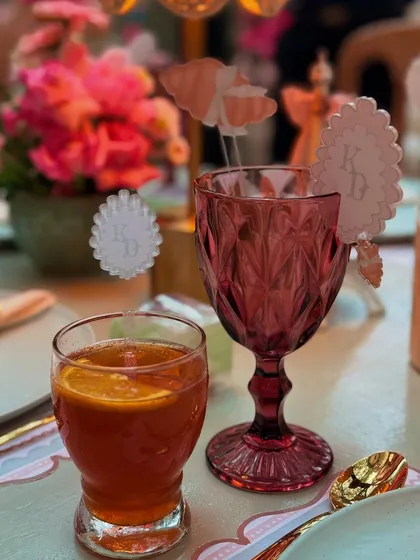 The rich color of the glassware contrasts beautifully with the soft pink florals and custom acrylic details on this elegant table.