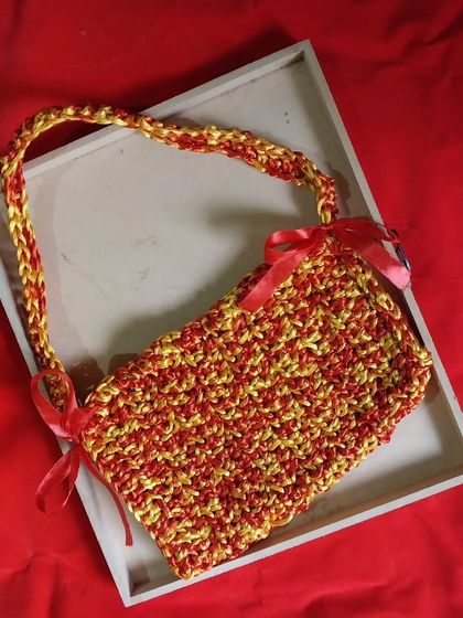 A vibrant red and yellow crochet bow bag. I made this custom piece based on a Pinterest inspiration photo for a client.