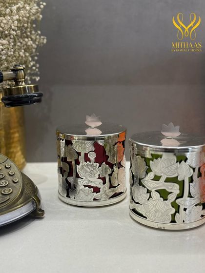 These silver-finished containers with intricate lotus cutouts are designed to be keepsakes. They hold my gourmet sweets, blending the richness of flavor with artistry and elegance, much like the grand Kothis of the past.