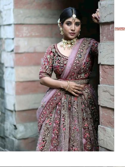 A complete bridal look. This model showcases one of our deep wine-colored velvet lehengas, paired with a stunning Kundan jewellery set, all available for rent.