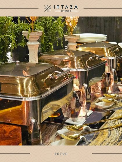 A mix of brass and silver chafing dishes set against a backdrop of lush greenery, perfect for an elegant garden party or daytime event.