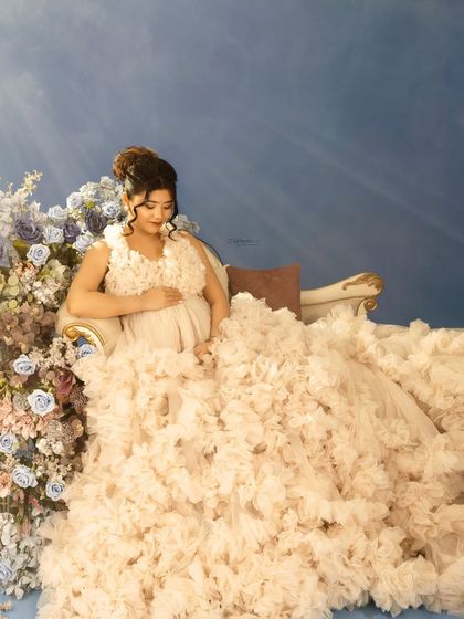 Bathed in a heavenly light, this portrait captures the ethereal beauty of pregnancy. The flowing gown and floral arrangement add to the dreamlike quality of the image.