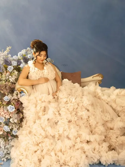 Bathed in a heavenly light, this portrait captures the ethereal beauty of pregnancy. The flowing gown and floral arrangement add to the dreamlike quality of the image.