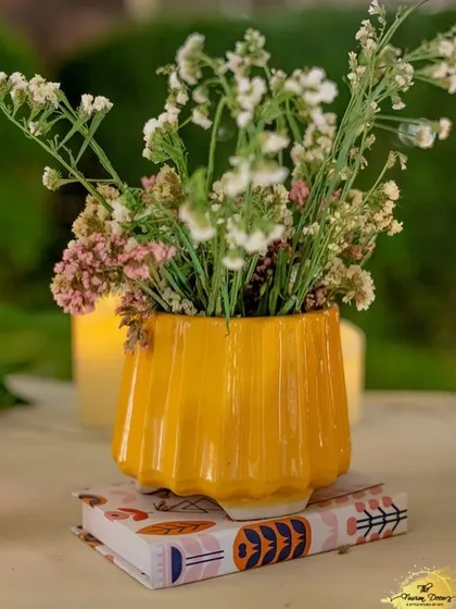 Even the smallest details matter. A simple yet cheerful yellow vase holding delicate baby's breath adds a small pop of colour and charm to a side table.