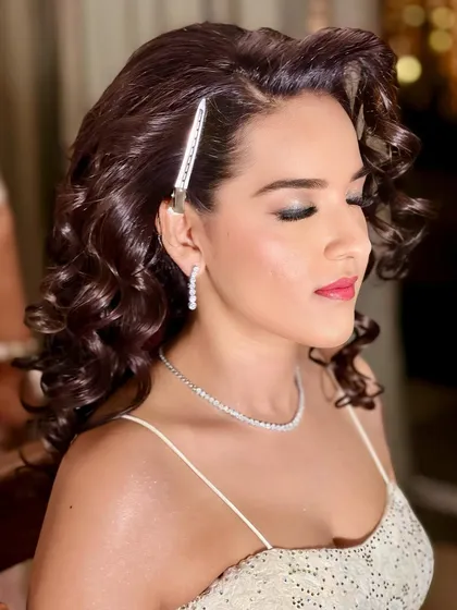 A close-up of the sangeet hairstyle in progress. I use clips to set the curls, ensuring they hold their shape and volume all night long. This technique is key for creating long-lasting Hollywood waves.