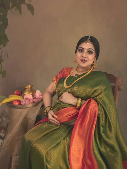 A seated portrait that feels like a classic still life painting. The arrangement of fruits and flowers beside the mother-to-be adds a layer of symbolism and artistry to this beautiful cultural maternity photo.