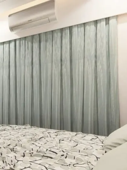 A close-up view of the bedroom, showing the sheer curtains that allow for soft, natural light.