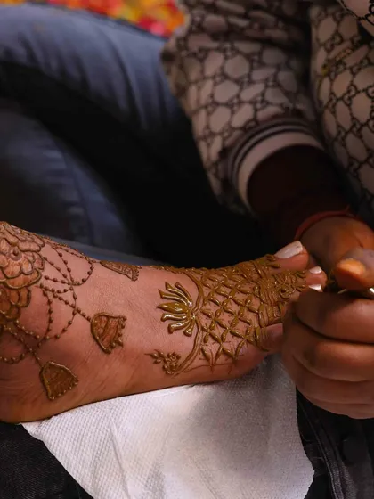 Mehndi isn't just for hands. Here, I am applying a detailed jewellery-style design on a client's foot, showing the precision and care I take with every part of the process.