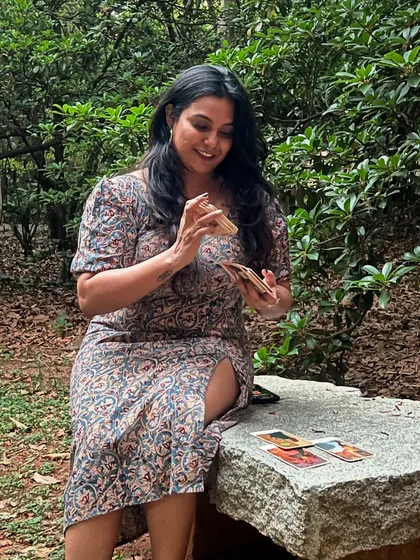Who else is ready to shuffle, cut, and reveal? A photo to celebrate World Tarot Day, with me sitting on a stone bench in nature, cards in hand, ready for the magic to unfold.