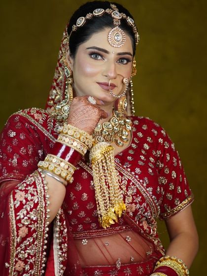 A series of portraits showcasing a bride in a traditional red lehenga. The focus is on the detailed craftsmanship of the outfit and the perfectly matched kundan jewellery.