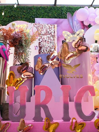 A close-up of the butterfly-themed decor for Aurica's birthday, showing the custom 3D name lettering, cake stands, and butterfly embellishments that make the theme feel complete.