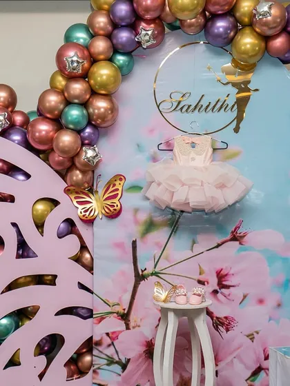 A special backdrop for Sahithi's birthday, featuring her first dress and shoes. This is a wonderful way to personalize a celebration.