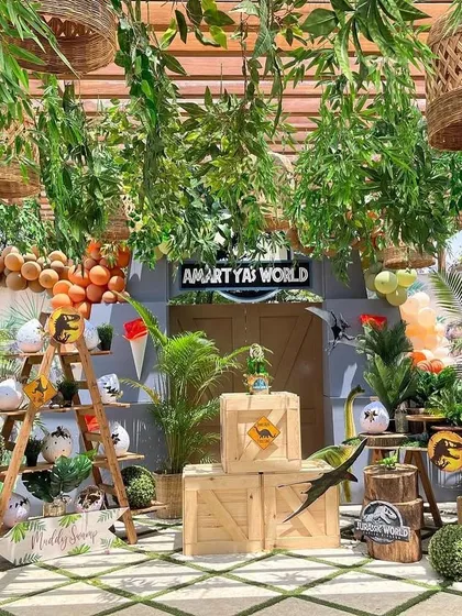Welcome to Jurassic World. This immersive setup featured a canopy of jungle foliage, wooden crates, and dinosaur props to make the birthday boy feel like he'd stepped into the movie.