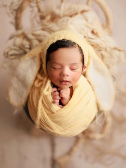 My little bunny. A soft yellow wrap and an adorable bunny-ear bonnet make for a super cute and whimsical portrait.