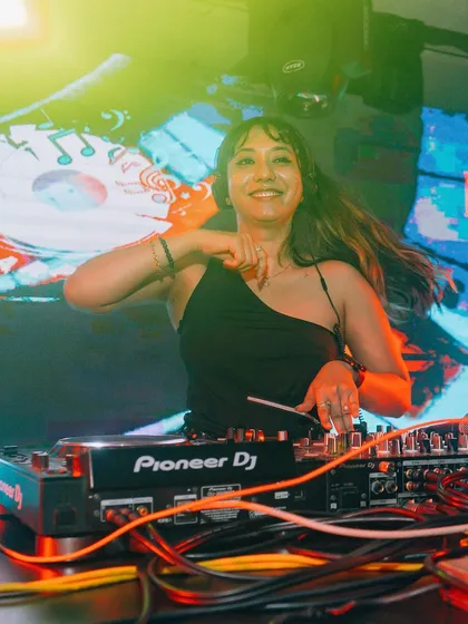 A candid shot capturing my joy while playing a high-energy set. Connecting with the audience through music is the best part of my job as a female DJ.