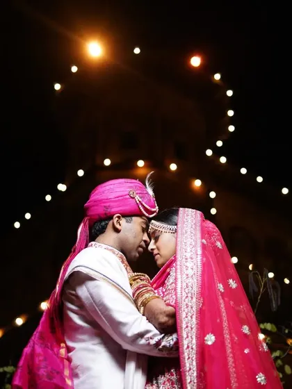 A romantic silhouette of the couple against a backdrop of festive lights, creating a dreamy and intimate wedding portrait.