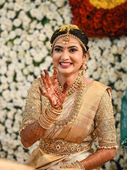 Rakshita waving happily, looking every bit the perfect South Indian bride in her gold Kanjeevaram and traditional jewellery.