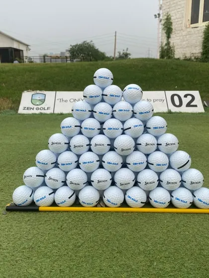 We ensure you have the best equipment for your practice. Here's a fresh pyramid of Srixon range balls, ready for your session.
