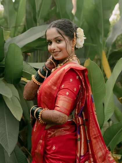 A happy and confident portrait of the bride amidst lush greenery.