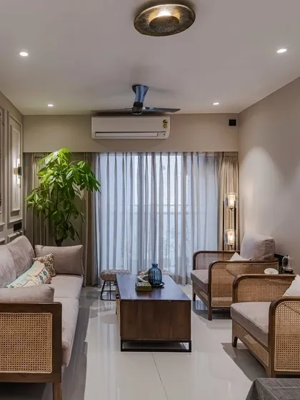 We craft spaces that blend classic comfort with contemporary style. This living room features our custom wooden and rattan furniture, with elegant moulding on the walls adding a layer of architectural detail. The cozy beige palette is accented with indigo blue for a touch of personality.