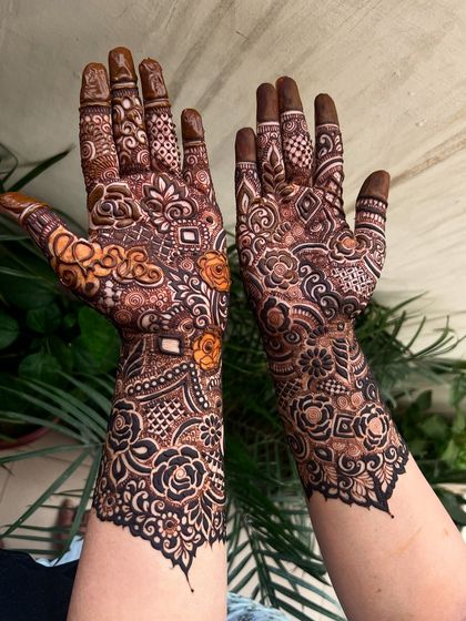 A beautiful heavy henna pattern with shaded roses and intricate details. The design covers the full arm.