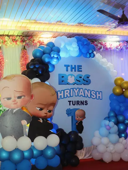 A close-up of the Boss Baby first birthday backdrop, showing the details of the balloon arch and custom banner.