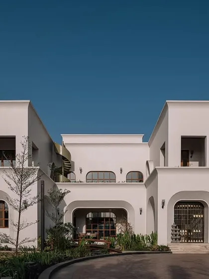 The architecture of our Rehethaan villa is a fusion of Mediterranean and Mid-Century styles. The clean white facade is punctuated by a series of arches and large wooden windows, creating a timeless and inviting multigenerational residence.