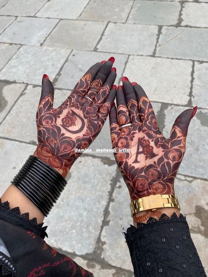 A stunning dark stain on a personalized design with the initials 'D' and 'A'. The contrast with the red nail polish is beautiful.