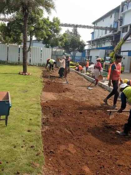 A wide shot showing the scale of the landscaping work, with multiple team members preparing the ground.