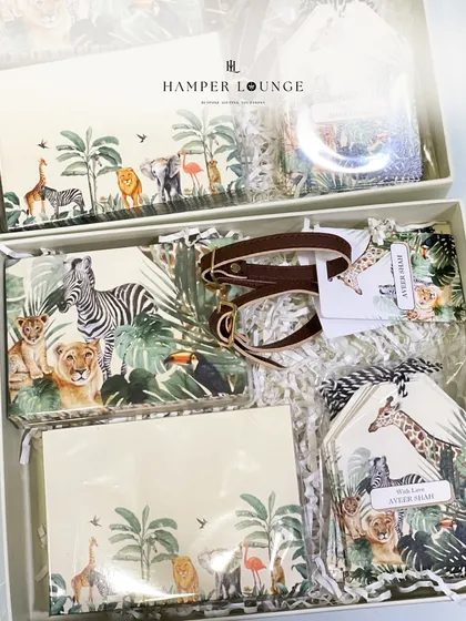 A look inside the safari return gift box, revealing a complete set of themed stationery, including notepads and luggage tags, all featuring beautiful jungle animal illustrations.