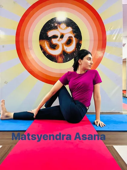 A student demonstrates Matsyendrasana, a seated spinal twist that detoxifies the internal organs and increases spinal flexibility.