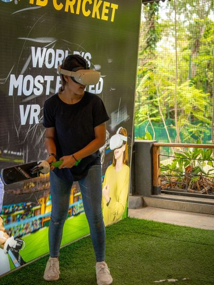 A guest gets into her batting stance, ready to face the virtual bowler in our VR Cricket game.
