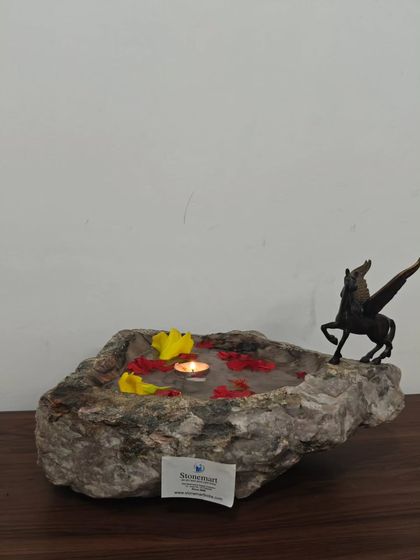 The contrast between the rough, natural edge and the polished water-filled basin is what makes this stone bowl so special. It's an exclusive piece for high-end interior decor.