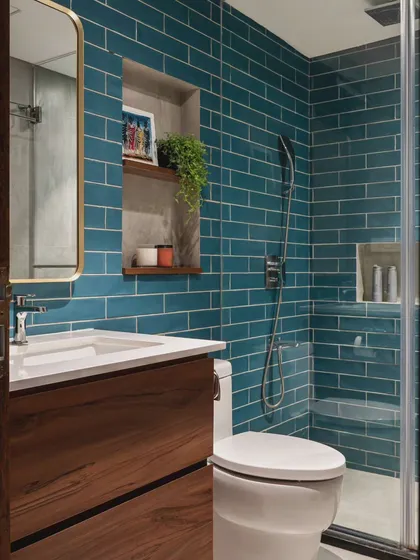 A bathroom can be a place to experiment with color and pattern. The vibrant teal subway tiles in this design bring so much life to the space, balanced by the warmth of the wooden vanity. It’s a functional room that doesn’t sacrifice style.