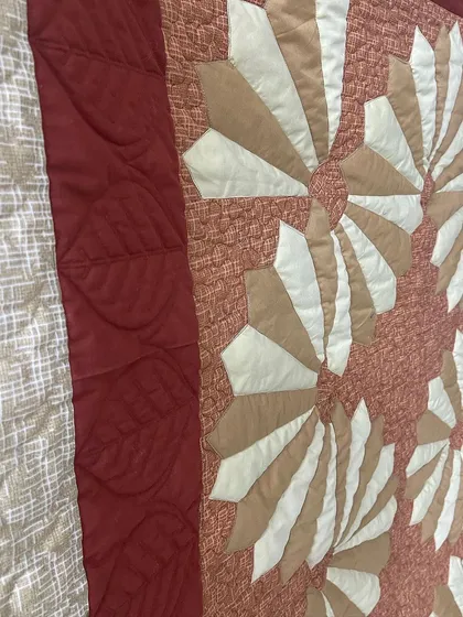 A close-up of the leaf-patterned quilting on the border.