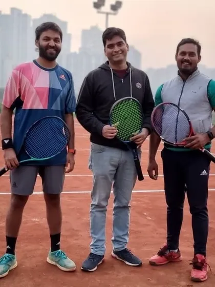 Three players from our men's tournament posing on the court. Our events are a great way to test your skills and meet other passionate tennis players in Noida.