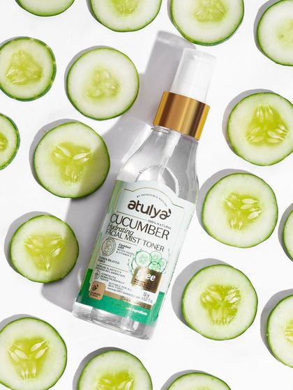 A flat-lay of a cucumber facial mist on a bed of fresh cucumber slices. This top-down shot is clean, fresh, and perfect for e-commerce.