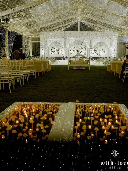 A unique dance floor created with a bed of candles and paper flowers, reflecting the shimmering Thikri work stage. This detail added a layer of romance and magic to the sangeet night, creating a truly memorable experience.