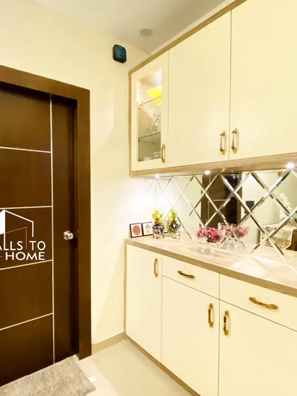 This elegant crockery unit features a diamond-patterned mirror backsplash and under-cabinet lighting. It provides ample storage while making the dining area feel more spacious and bright.