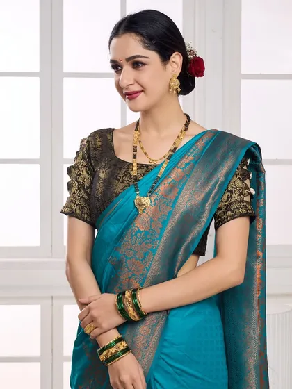 A close-up shot focusing on the model's expression and the fine details of a gold mangalsutra and matching earrings. The soft lighting and traditional attire make this perfect for showcasing wedding jewellery collections.