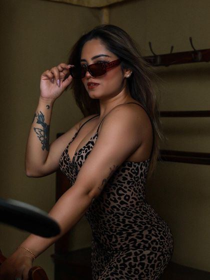 A close-up portrait of the model in sunglasses, exuding confidence and style.