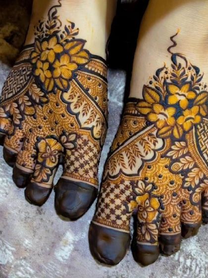 A close up of a beautiful floral foot design, showing the two-tone effect of the fresh henna paste.