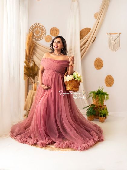 This shot captures a bright, happy expression, showcasing the beauty of the mauve gown and the charming studio set.